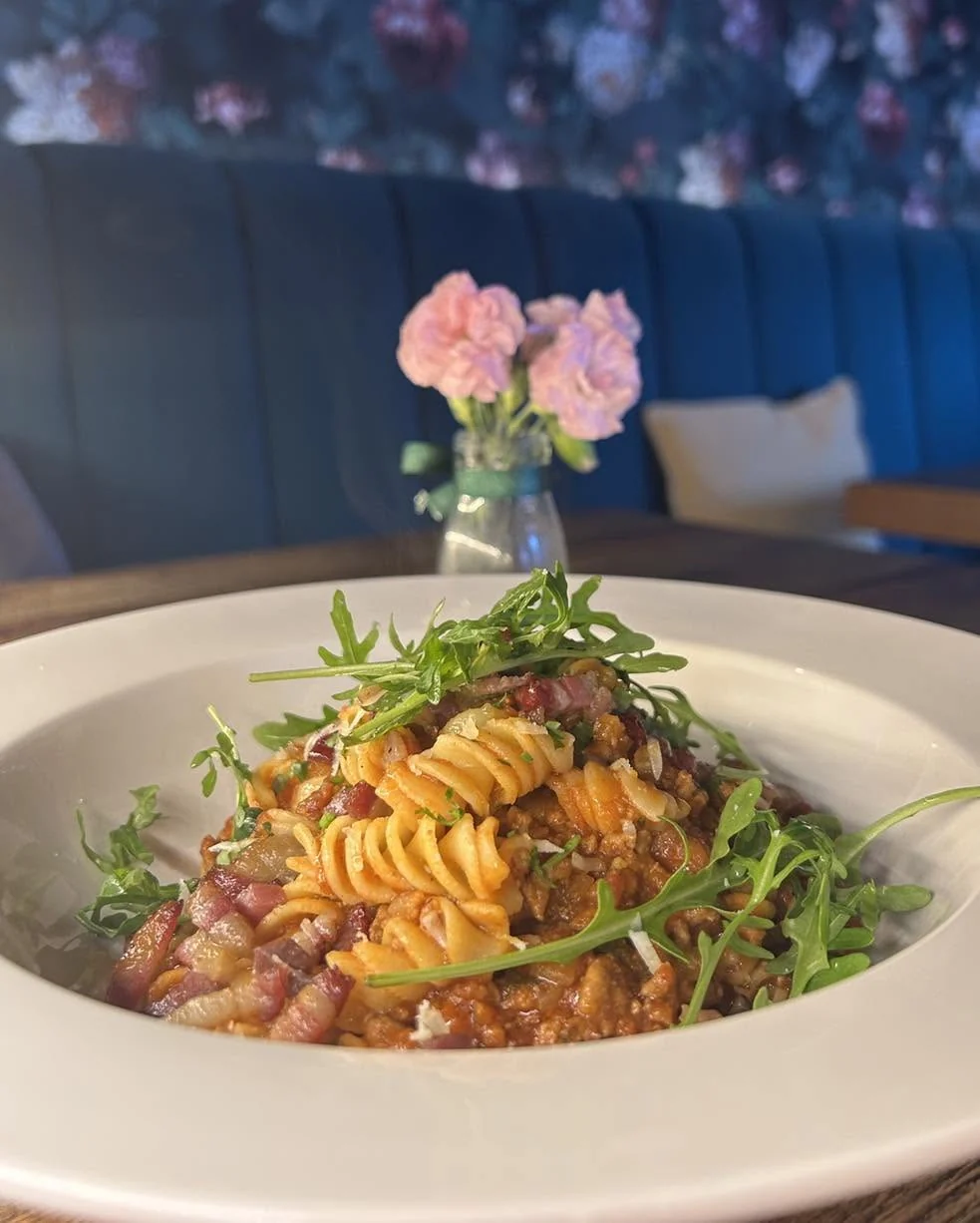Fusilli with a rich tomato and bacon sauce, topped with rocket